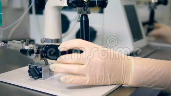 手套技师手转动显微镜旋钮视频的预览图