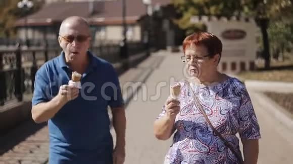 在阳光明媚的日子里老夫妇在长廊里吃冰淇淋视频的预览图