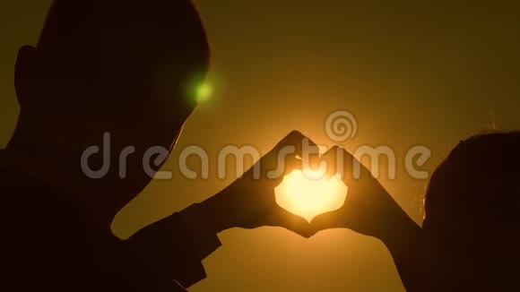手里拿着太阳一对相爱的夫妇的团队合作相爱的夫妇用手显示心脏的象征新郎新娘做一颗心视频的预览图