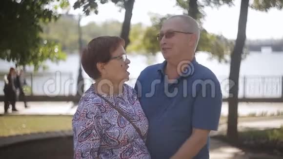 快乐的老年夫妇在户外恋爱阳光花园里快乐的老年夫妇视频的预览图