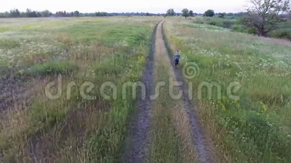 乡村公路上男孩奔跑的空中镜头夏季农业领域乌克兰性质视频的预览图