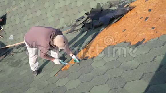 拆除软顶法国绿瓦roofer在倾斜的屋顶上工作一个留着胡子的人从一个老人身上流下眼泪视频的预览图