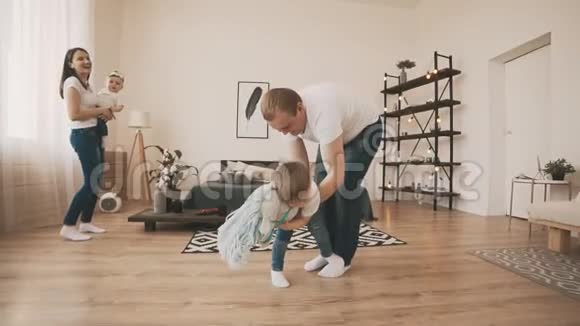 年轻的父亲和小儿子在家里玩玩具马慢慢的动作视频的预览图
