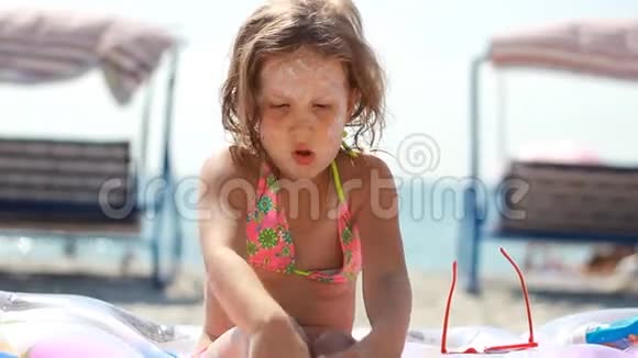 儿童涂抹太阳霜的节日和身体晒伤防晒霜防晒霜戴太阳镜可爱的女婴视频的预览图