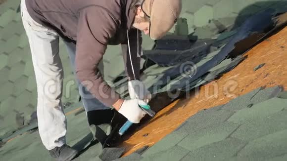 拆除软顶法国绿瓦roofer在倾斜的屋顶上工作一个留着胡子的人从一个老人身上流下眼泪视频的预览图
