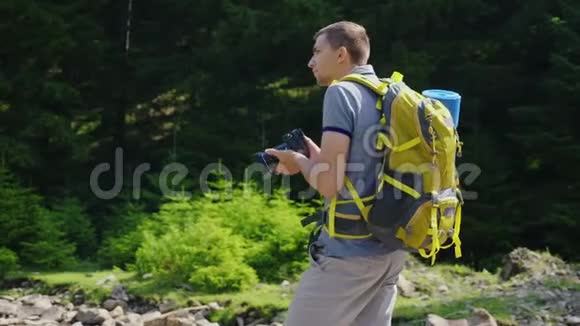 一个人拍一张美丽的大自然的照片站在森林的背景下背着背包视频的预览图