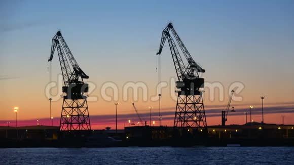 日落背景上港口起重机的剪影芬兰科特卡视频的预览图