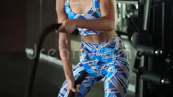 运动女性积极参加体育锻炼与战斗绳索在她的交叉健身锻炼慢动作视频的预览图