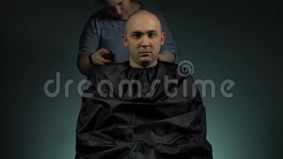 发型师给一个黑发男人刮胡子视频的预览图