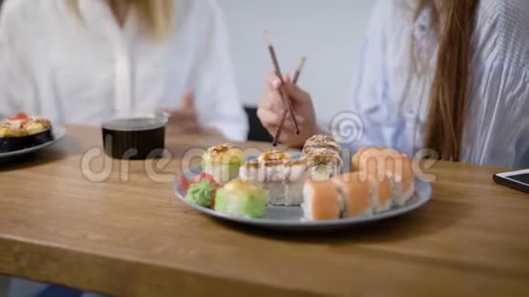 特写镜头一个两盘不同的寿司卷女生用筷子吃寿司视频的预览图