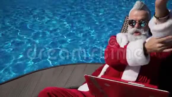 有趣的圣诞老人在暑假用笔记本电脑打字视频的预览图