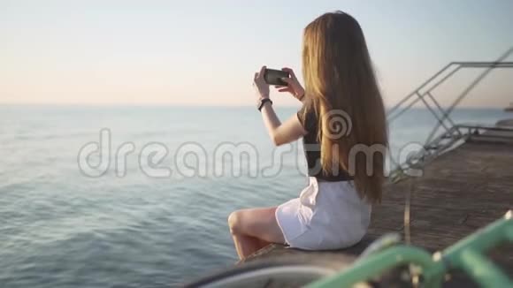 日落或日出时拍海的年轻有魅力的女人视频的预览图