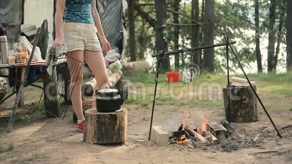 野餐的女人把水壶挂在火上视频的预览图