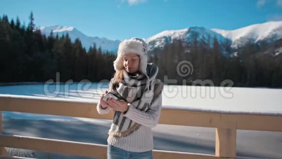 可爱的女士用智能手机拍摄自助背景为山景视频的预览图