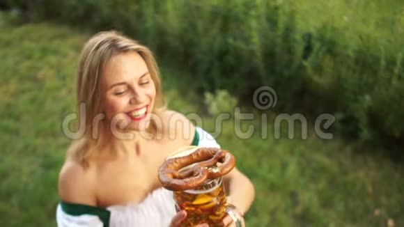 在啤酒节上穿着传统巴伐利亚服装的年轻女孩买啤酒和脆饼女人会笑视频的预览图