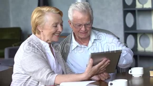 在舒适的客厅里一对老夫妇在网上与家人交流时很开心视频的预览图