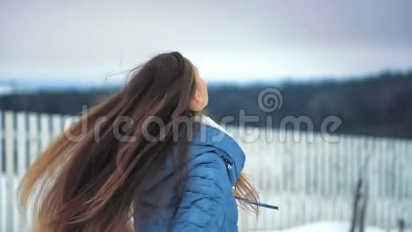 年轻漂亮的女人在冬季公园玩得很开心笑着四处走动视频的预览图