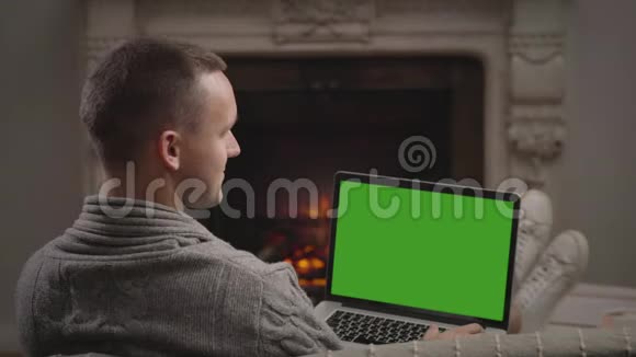 一动不动的年轻人在客厅里用笔记本电脑看电影的画面视频的预览图