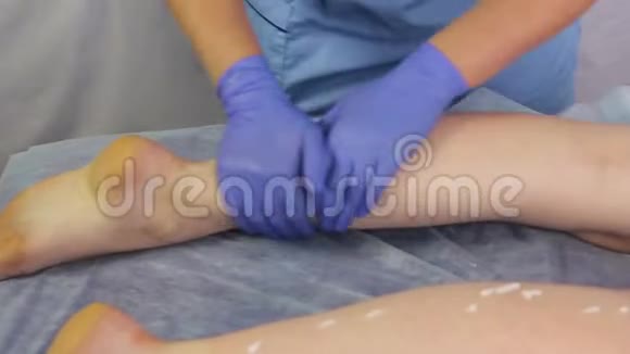 美容师女人的手用奶油滋润女孩脚视频的预览图