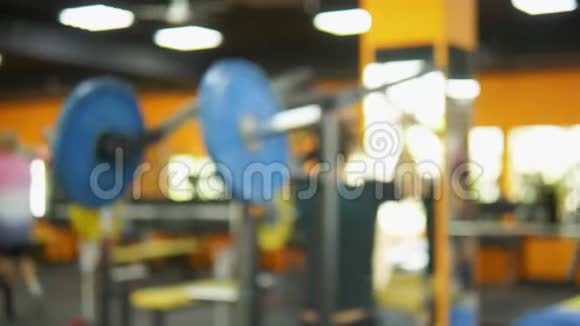 模糊的背景健身房里的杠铃带重量训练杆的模糊健身室视频的预览图