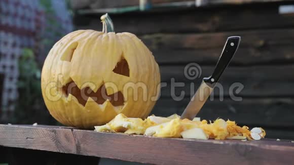一个南瓜和一个灯笼杰克躺在桌子上旁边切蔬菜在刀棒旁边视频的预览图