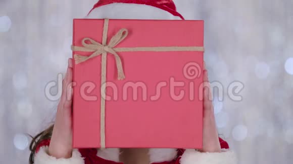 圣诞老人助理用礼物遮住了她的脸向外看着他博克背景快关门慢动作视频的预览图