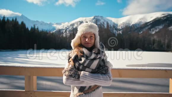 皮帽中的女士与尼斯山和雪背景的冬季画像视频的预览图