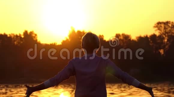 快乐的人总是在夕阳西下的湖面上举起拳头视频的预览图