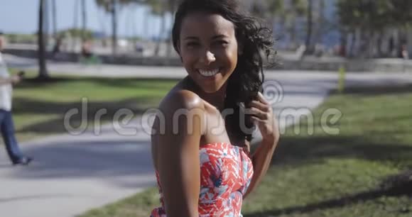 穿着裙子笑着相机的迷人黑人女孩视频的预览图