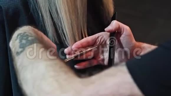 理发师剪一个金发的女人剪发特写视频的预览图
