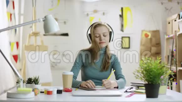 听音乐做家庭作业的漂亮年轻女人视频的预览图