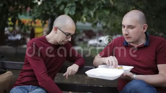 两个人在公园长椅上聊天吃薯条视频的预览图