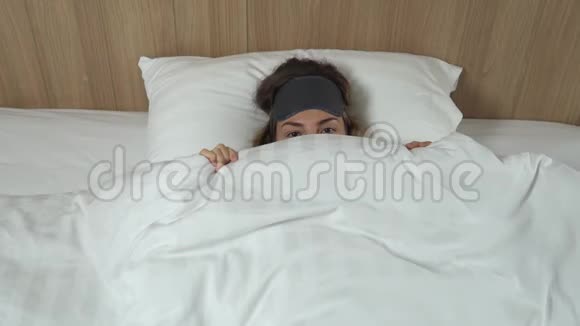 有趣的阿多尔特女孩醒来后在柔软的床上用白色毯子遮住自己头上戴着睡面具角度很高视频的预览图
