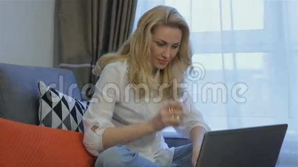 女人在家里用笔记本聊天视频的预览图