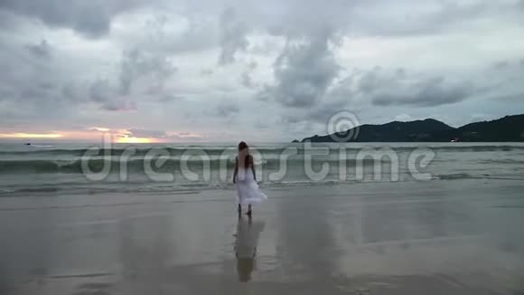 日落时分在夏日海滩散步的塔纳格女孩剪影视频的预览图