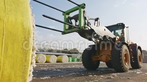 大型拖拉机在加工前用棉子酒装棉花包视频的预览图