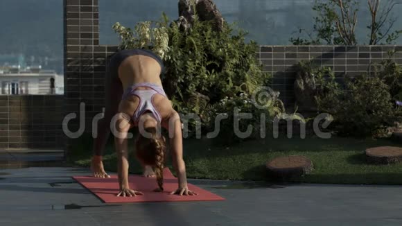 女孩持瑜伽姿势站在露台的凯雷马特视频的预览图