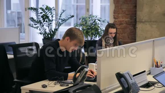 网上商店的男经理使用笔记本电脑咨询客户的生产视频的预览图