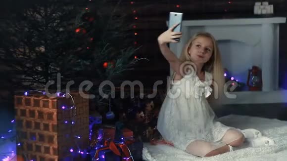 坐在圣诞树下拍照的女孩视频的预览图