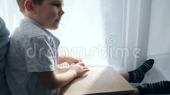 盲人的生活在窗台上看盲人男孩的盲文书视频的预览图