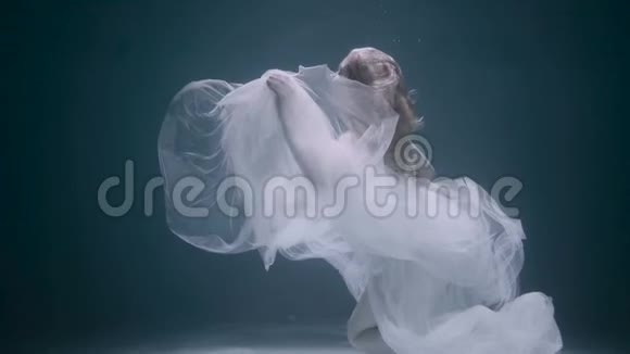 美丽的女人在水下游泳穿着白色优雅的衣服视频的预览图