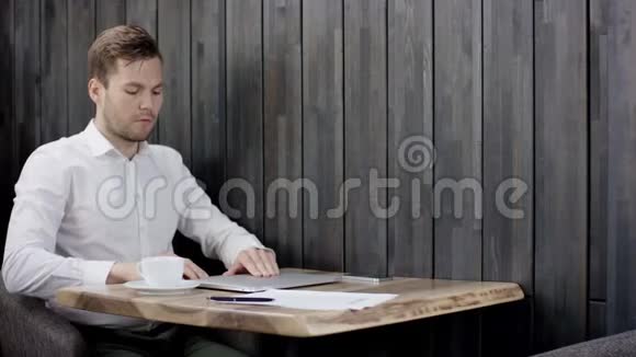 帅哥用他的笔记本电脑工作商人坐在餐厅的桌子旁打开他的电脑一个人坐在视频的预览图