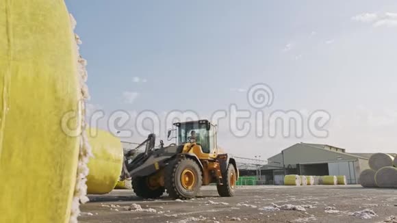 大型拖拉机在加工前用棉子酒装棉花包视频的预览图