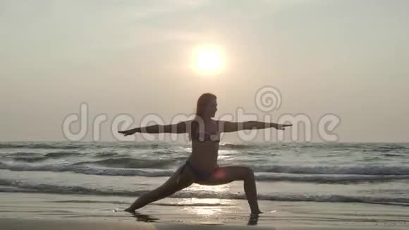 一个在海边日落的女孩正在做瑜伽4K视频的预览图