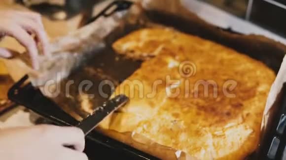 女厨师用手拿着粘粘的自制馅饼从厨房托盘上拿下来的特写镜头视频的预览图