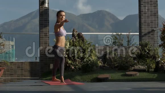 女子站在瑜伽位置的屋顶露台视频的预览图