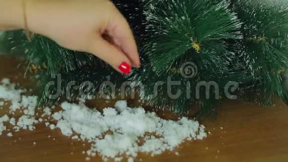女性的手仿雪手工装饰圣诞树视频的预览图
