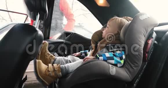 男人帮孩子系安全带婴儿车座椅视频的预览图