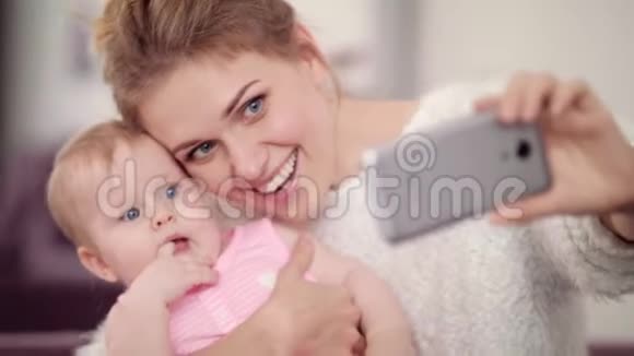 微笑的妈妈和女婴拍自拍照片一位女士带着一张视频的预览图