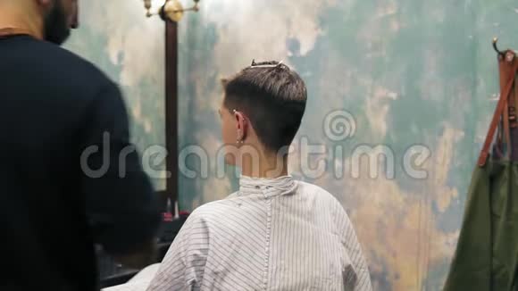 胡子理发师用电动修剪器在一个人的寺庙创造一条直线年轻英俊的白种人视频的预览图